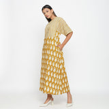 Left View of a Model wearing Mustard Block Printed Cotton Ankle Length Snug Dress