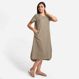 Right View of a Model wearing Beige Cotton Welt Pocket Shift Dress