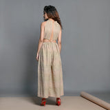 Back View of a Model wearing Beige Striped Handwoven Cotton Plunge Neck Blouson Jumpsuit