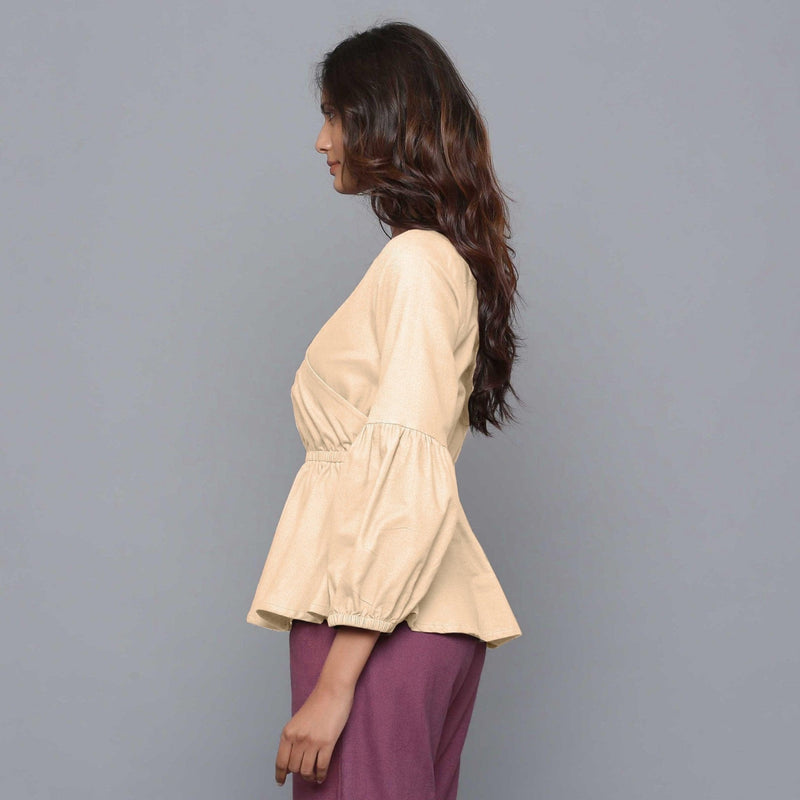 Left View of a Model wearing Beige V-Neck Flannel Peplum Top