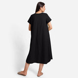 Back View of a Model wearing Black Cotton Welt Pocket Shift Dress