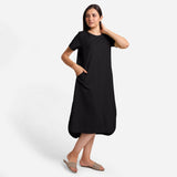 Right View of a Model wearing Black Cotton Welt Pocket Shift Dress