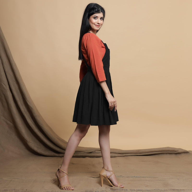 Right View of a Model wearing Black Pleated Cotton Flax Knee Length Criss-Cross Back Dress