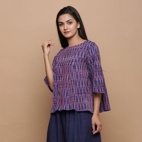 Left View of a Model wearing Blue Ikat Boat Neck Flared Godet Top