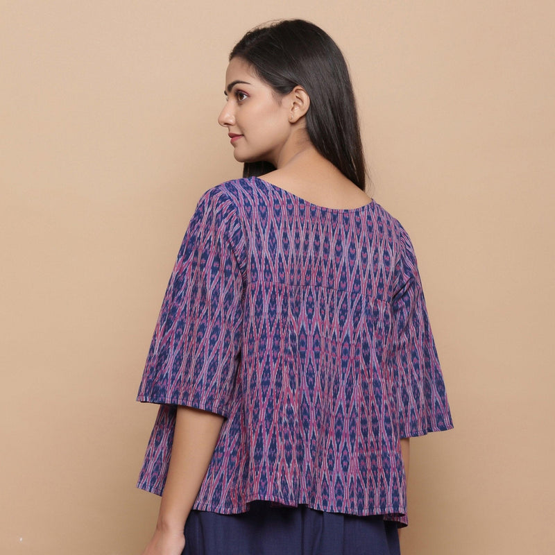 Back View of a Model wearing Blue Ikat Boat Neck Flared Godet Top