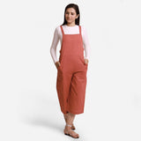 Front View of a Model wearing Brick Red 100% Cotton Pinafore Midi Dungaree