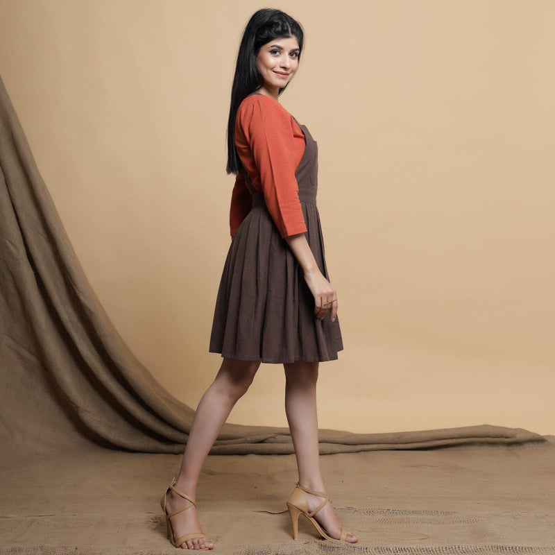 Right View of a Model wearing Brown Pleated Criss-Cross Back Dress