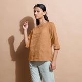 Left View of a Model wearing Desert Yellow 100% Linen Split-Neck Tunic Top