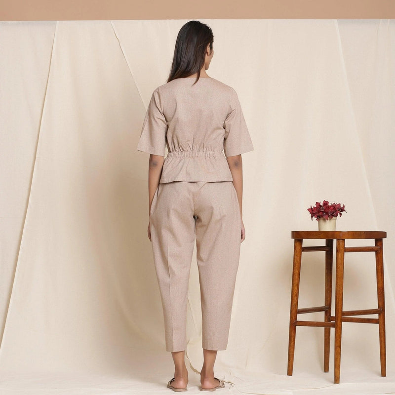 Back View of a Model wearing Dusk Beige Plunge Neck Peplum Top