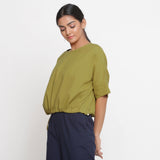 Left View of a Model wearing Solid Green Cotton Flax Blouson Top