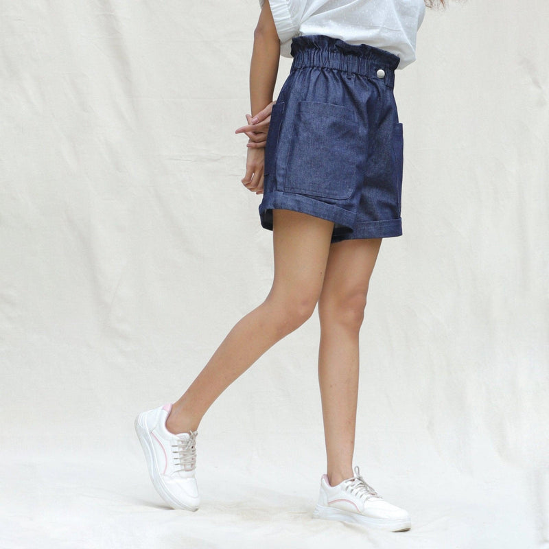 Right View of a Model wearing Indigo Cotton Denim High-Rise Paperbag Elasticated Shorts