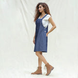 Left View of a Model wearing Indigo Cotton Denim Pinafore Knee Length Dress