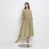 Front View of a Model wearing Green Vegetable Dyed Handspun Cotton Round Neck Button-Down Midi Dress