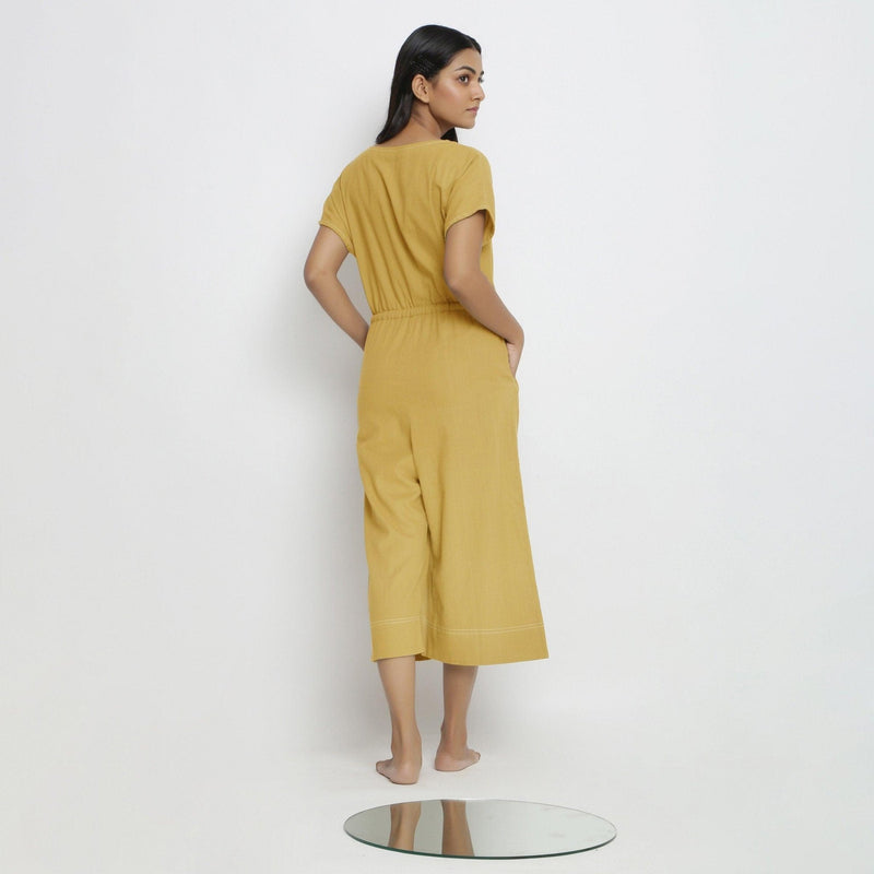 Back View of a Model wearing Light Yellow Vegetable Dyed Button-Down Jumpsuit