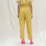 Back View of a Model wearing Mustard Handspun Cotton High-Rise Elasticated Paperbag Pant