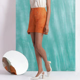 Left View of a Model wearing Melon Orange Handspun Mirror Work Shorts