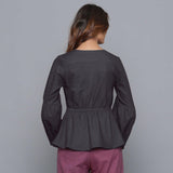 Back View of a Model wearing Moonlight Black V-Neck Flannel Peplum Top