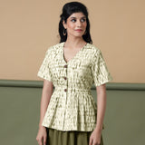 Front View of a Model wearing Shibori Button-Down Green Peplum Top