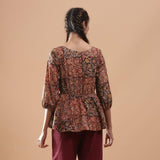 Back View of a Model wearing Muddy Red Kalamkari Floral Peplum Top