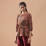 Left View of a Model wearing Muddy Red Kalamkari Floral Peplum Top