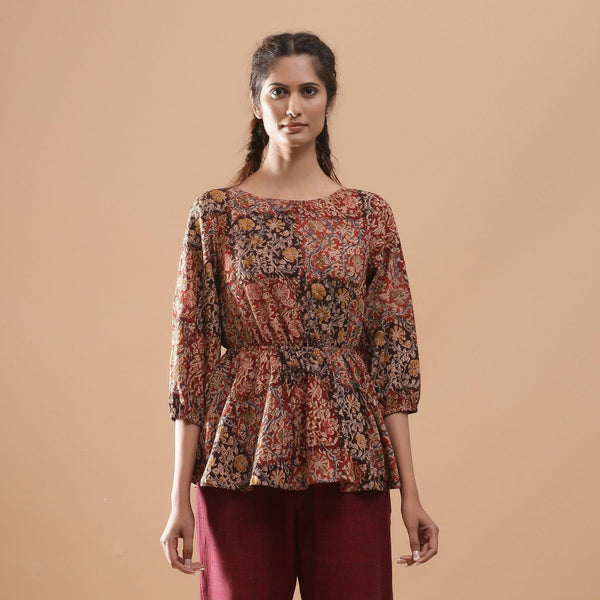 Front View of a Model wearing Muddy Red Kalamkari Block Print Cotton Peplum Top