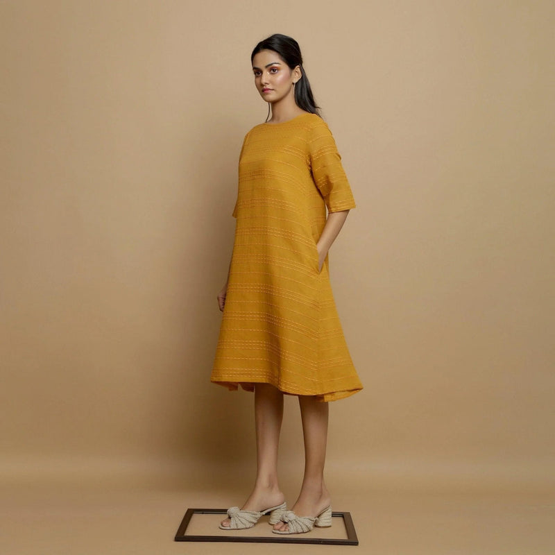 Left View of a Model wearing Mustard Striped Handwoven Godet Dress