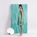 Left View of a Model wearing Ocean Green Handspun Cotton Criss-Cross A-Line Short Dress