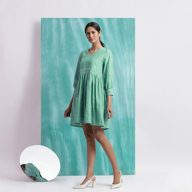 Left View of a Model wearing Ocean Green Handspun Cotton V-Neck Gathered Short Dress