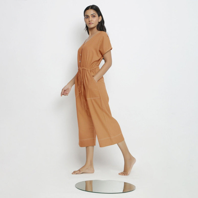 Left View of a Model wearing Rust Vegetable Dyed Button-Down Jumpsuit