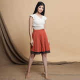 Right View of a Model wearing Orange and Brown Reversible Pleated Flared Skirt