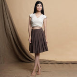 Front View of a Model wearing Orange and Brown Reversible Pleated Flared Skirt