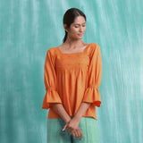 Front View of a Model wearing Orange Handspun Mirror Work Yoked Top