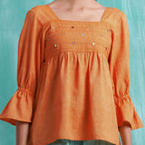 Front Detail of a Model wearing Orange Handspun Mirror Work Yoked Top