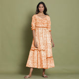 Front View of a Model wearing Orange Shibori Asymmetrical Tier Maxi Dress