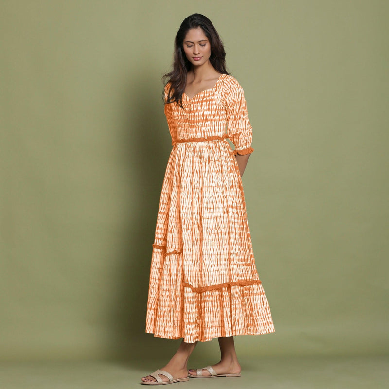 Left View of a Model wearing Orange Shibori Asymmetrical Tier Maxi Dress