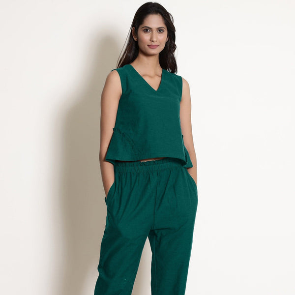 Front View of a Model wearing Warm Pine Green V-Neck Flared Top