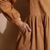 Close View of a Model wearing Rust Handspun Solid Gathered Dress