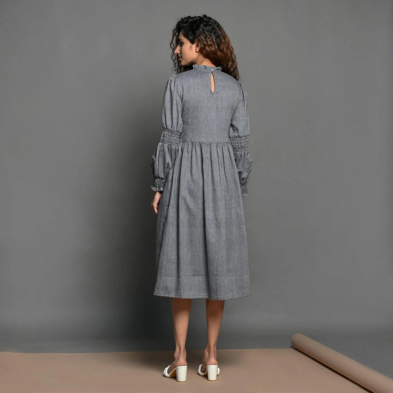 Back View of a Model wearing Slate Grey Handspun Cotton Knee Length Frilled Peasant Dress