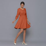 Right View of a Model wearing Sunset Rust V-Neck Corduroy Dress