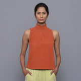 Front View of a Model wearing Sunset Rust Cotton Corduroy High Neck Top