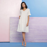 Front View of a Model wearing Organic Cotton White Embroidered V-Neck Dress