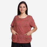 Front View of a Model wearing Brick Red Block Print Flared Round Neck Cotton Top