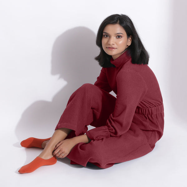 Left View of a Model wearing Barn Red Cotton Waffle Turtle Neck Overalls