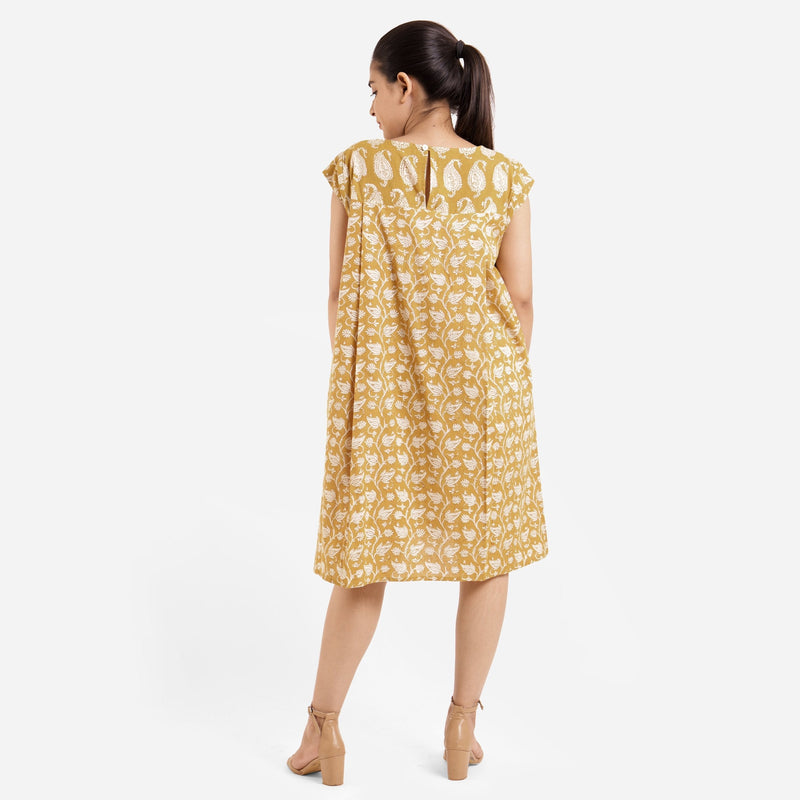 Back View of a Model wearing Mustard Block Printed Cotton Knee Length Yoke Dress