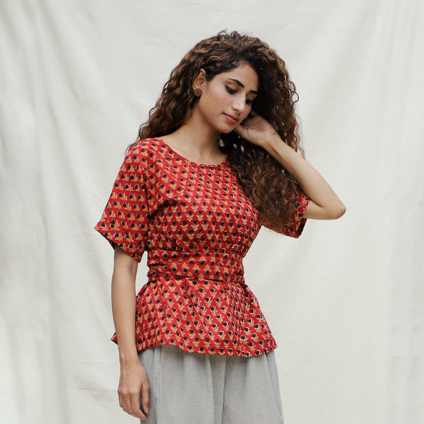 Right View of a Model wearing Brick Red Floral Block Printed Cotton Peplum Top