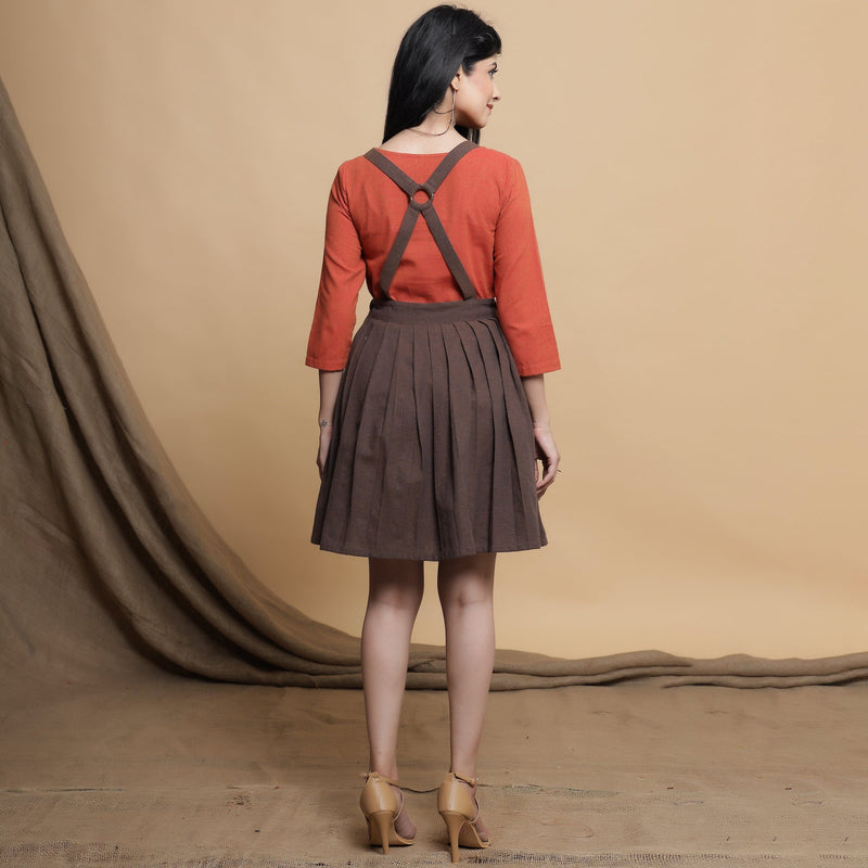 Back View of a Model wearing Brown Pleated Criss-Cross Back Dress