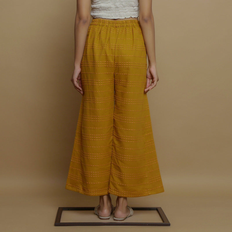 Back View of a Model wearing Mustard Paneled Striped Handwoven Pant