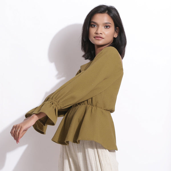 Left View of a Model wearing Cotton Waffle Olive Green Peplum Top