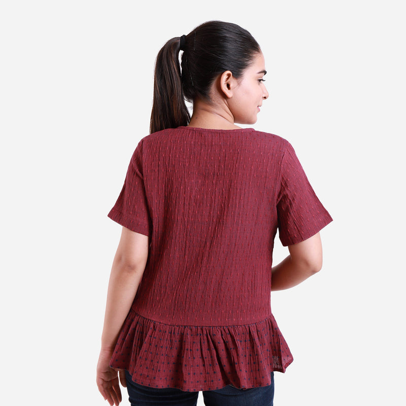 Back View of a Model wearing Crimson Crinkled Cotton Polka Dot Peplum Top