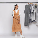 Front View of a Model wearing Desert Yellow 100% Linen V-Neck Midi Pinafore Dress